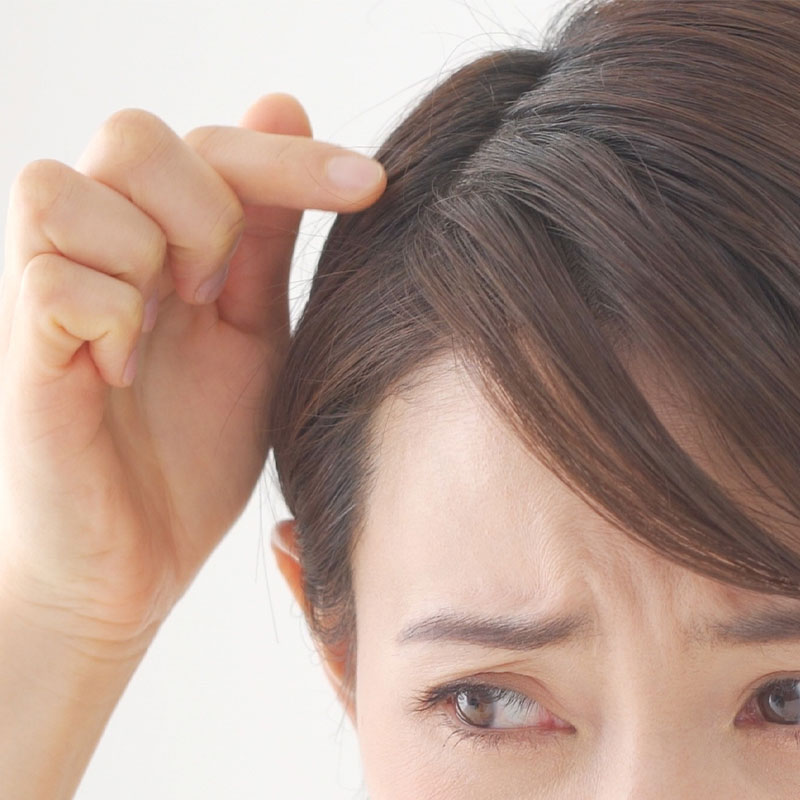 髪のダメージを気にする女性