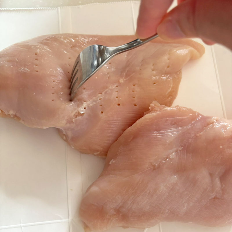 鶏肉をフォークで刺す
